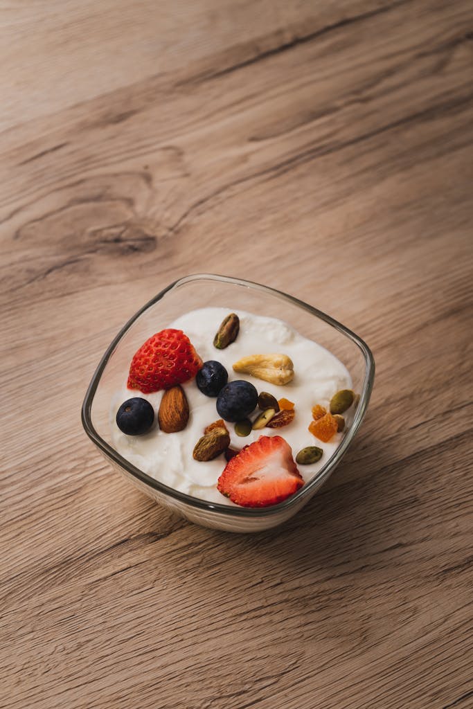 A bowl of yogurt topped with fresh strawberries